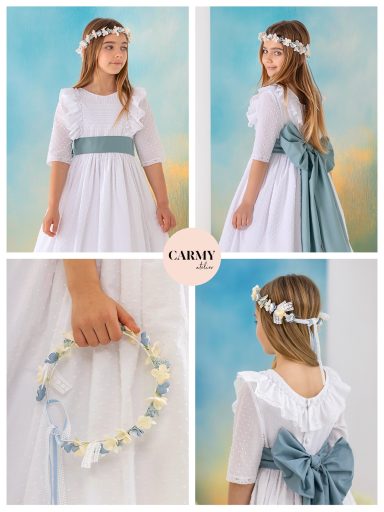 Niña con vestido blanco y cinta verde, decorada con una corona de flores.