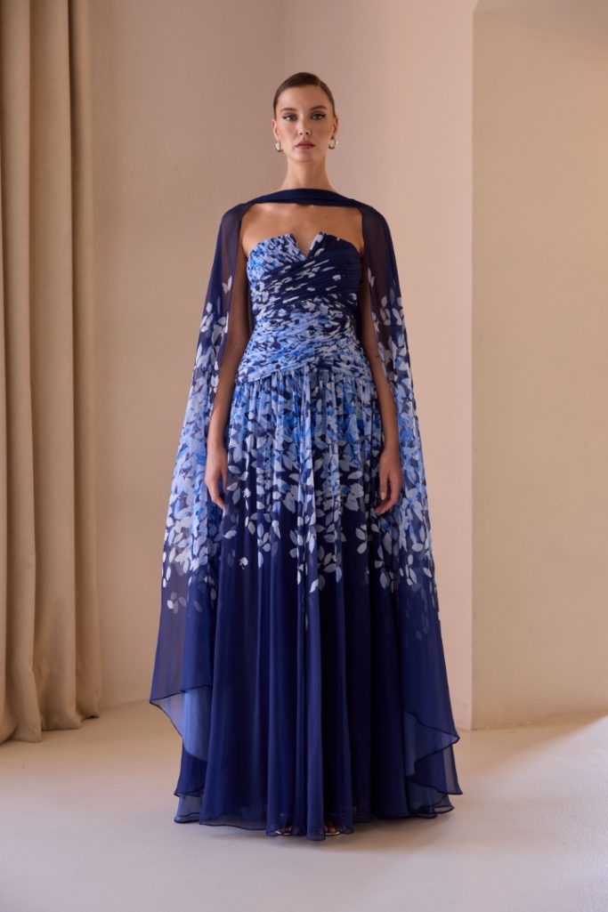 Vestido largo azul con detalles florales y capa transparente. Elegancia y sofisticación.