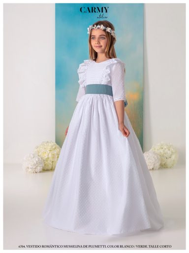 Niña con vestido blanco y cinta turquesa, fondo azul claro y flores blancas.