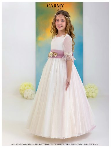 Niña con vestido blanco y rosa, sonriendo, con fondo suave y flores blancas.