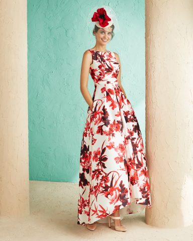 Vestido largo con estampado floral rojo y blanco, con un tocado decorativo.