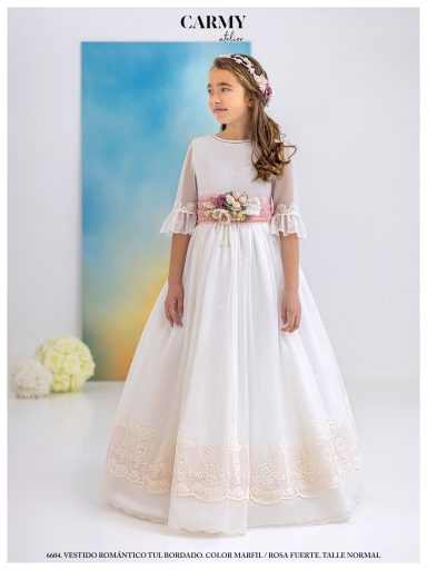 Niña vestida con un elegante vestido blanco y adornos en la cintura.