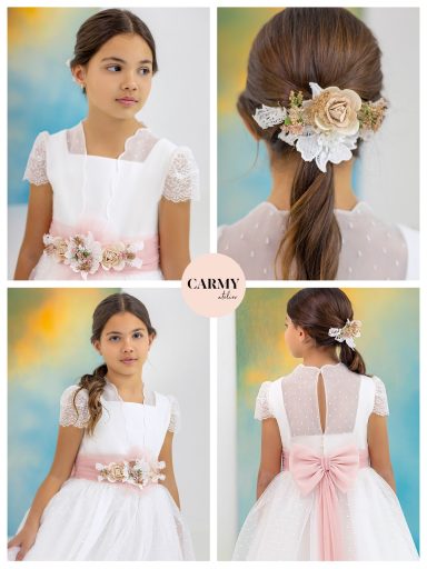 Niña con vestido blanco, lazo rosa y peinado con flores. Fondo de colores suaves.